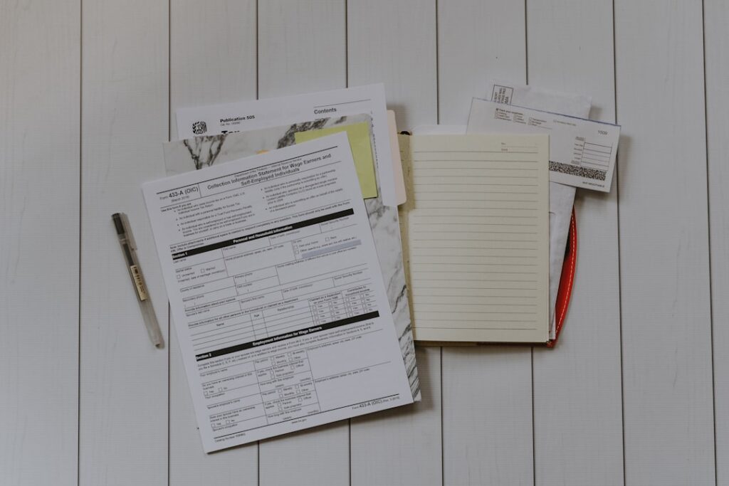 Stack of official documents and forms on a white surface, representing NYSDOT mover licensing and insurance paperwork