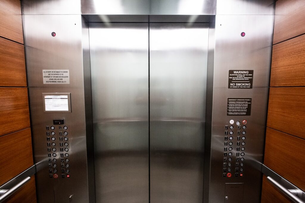 Service elevator interior with posted notices and control panel, illustrating the importance of confirming elevator reservations before moving day.